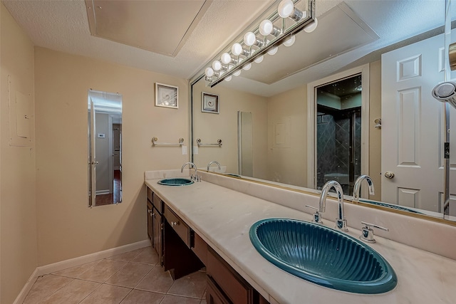 bathroom with tile patterned flooring, a textured ceiling, and vanity