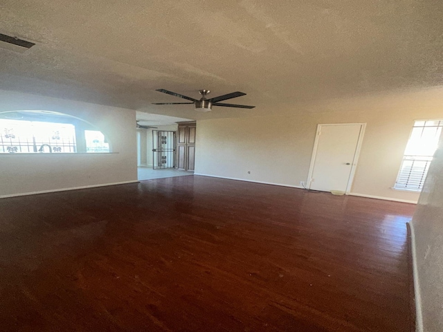 spare room with dark hardwood / wood-style floors, ceiling fan, and a textured ceiling