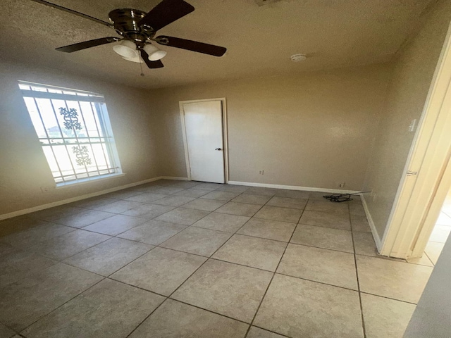 empty room with light tile patterned floors and ceiling fan