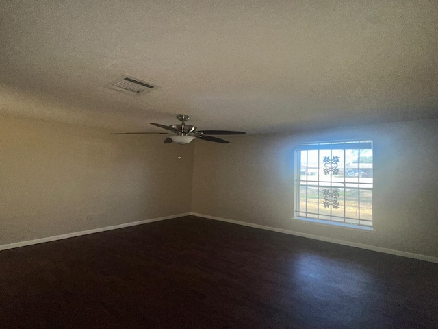 empty room featuring ceiling fan, dark hardwood / wood-style flooring, and a textured ceiling