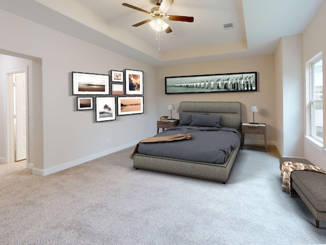 bedroom featuring carpet, a tray ceiling, and ceiling fan