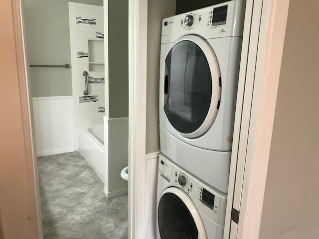 laundry area with stacked washing maching and dryer