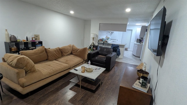 living room with dark hardwood / wood-style floors and a textured ceiling