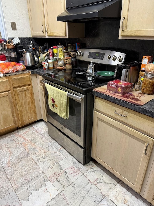 kitchen featuring dark countertops, stainless steel range with electric cooktop, and under cabinet range hood