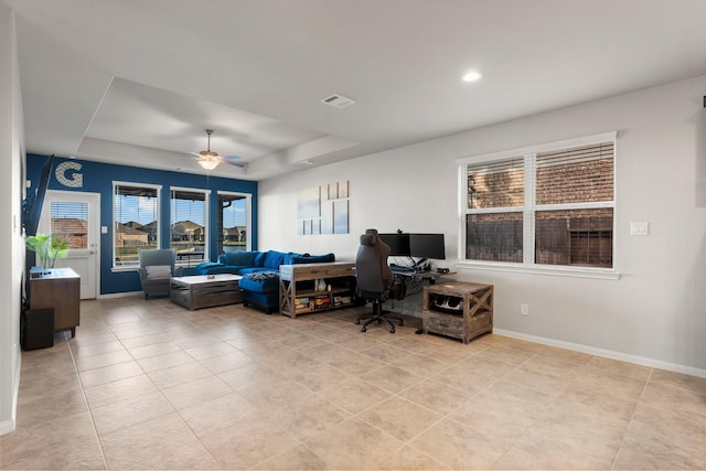 tiled office with a raised ceiling and ceiling fan