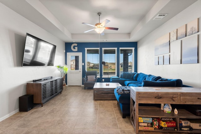 living room with a tray ceiling, ceiling fan, french doors, and light tile patterned flooring