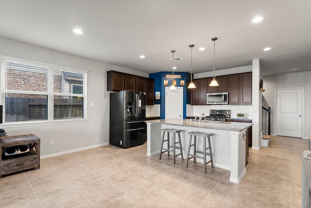 kitchen with backsplash, dark brown cabinetry, stainless steel appliances, and a breakfast bar area