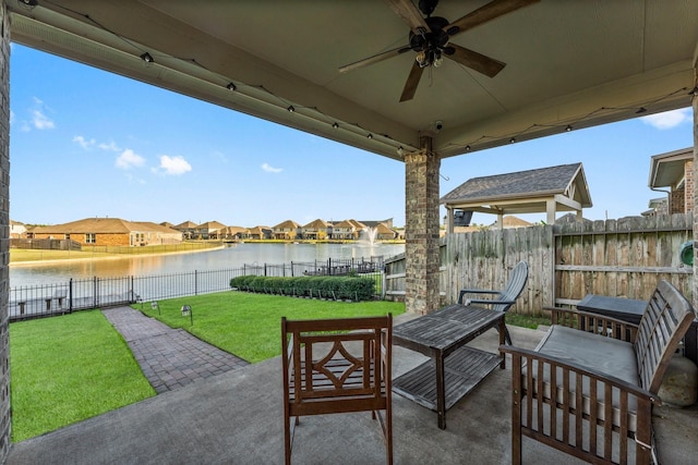 view of patio with ceiling fan and a water view