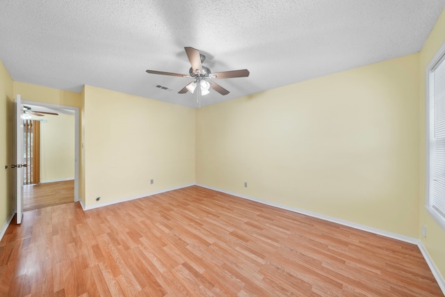 spare room with a textured ceiling and light wood-type flooring