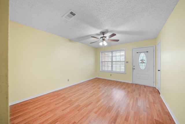 entryway featuring a textured ceiling, light hardwood / wood-style floors, and ceiling fan