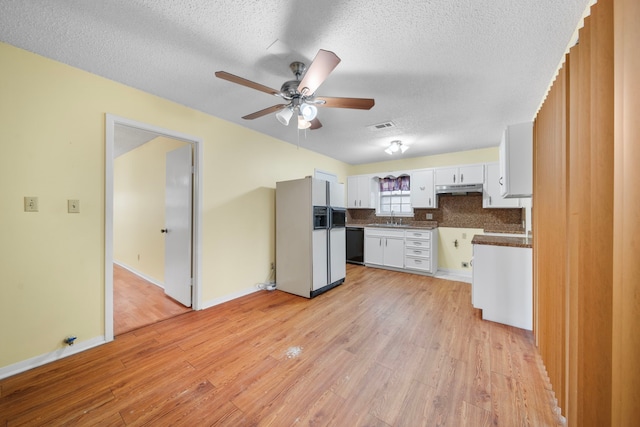 kitchen featuring white cabinetry, white fridge with ice dispenser, light wood-type flooring, and black dishwasher