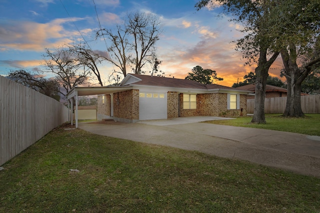 ranch-style house featuring a garage and a yard