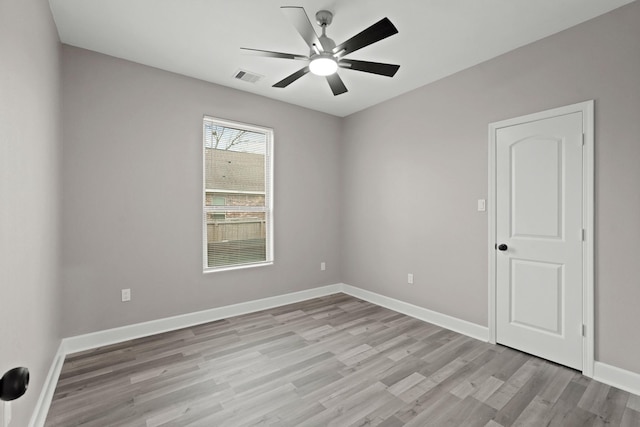 empty room with light wood-style floors, baseboards, visible vents, and ceiling fan