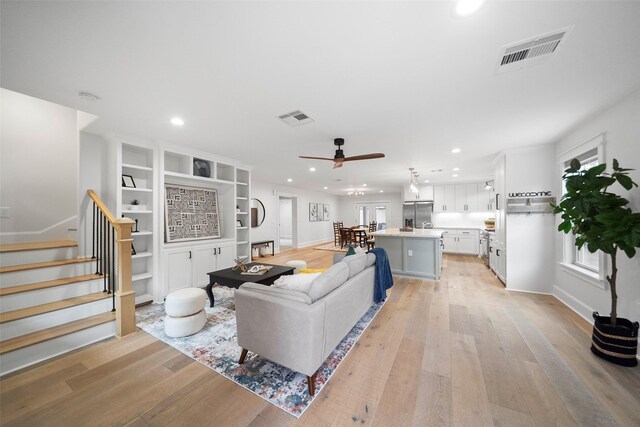 living room featuring light hardwood / wood-style floors and ceiling fan