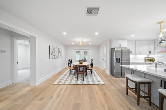 dining area with ceiling fan, light hardwood / wood-style floors, and french doors