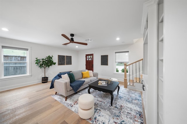 living room with ceiling fan and light hardwood / wood-style flooring