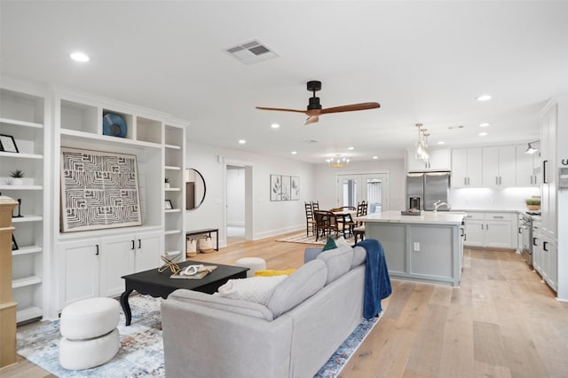 living room featuring french doors, light hardwood / wood-style flooring, and ceiling fan