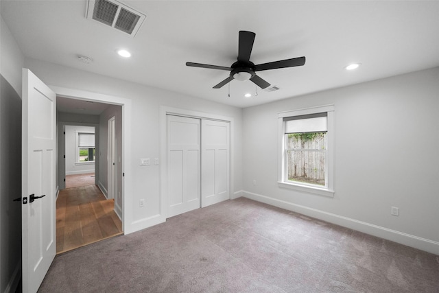 unfurnished bedroom featuring carpet flooring, ceiling fan, and a closet