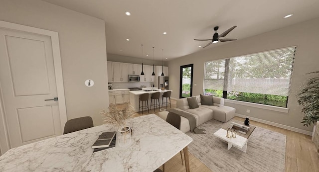 living room featuring ceiling fan and light hardwood / wood-style flooring