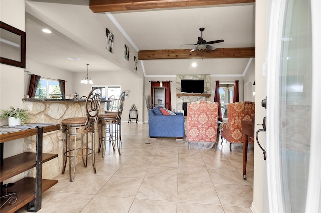 tiled living room featuring crown molding, a fireplace, beamed ceiling, and ceiling fan with notable chandelier