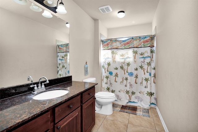 bathroom featuring tile patterned flooring, vanity, and toilet