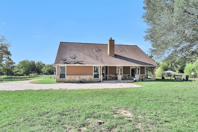 back of property with a lawn and a patio area