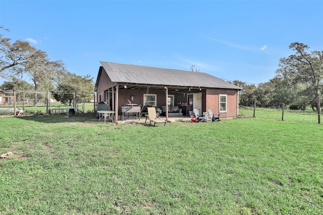 rear view of house with ceiling fan, a yard, and a patio