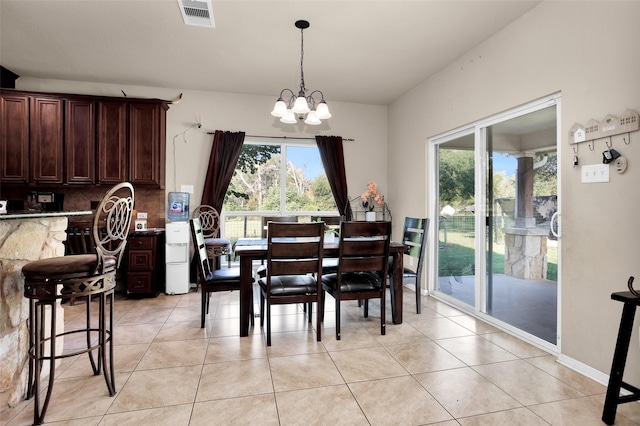 dining room with light tile patterned flooring and an inviting chandelier