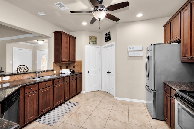 kitchen with dishwasher, light tile patterned floors, dark stone counters, and sink