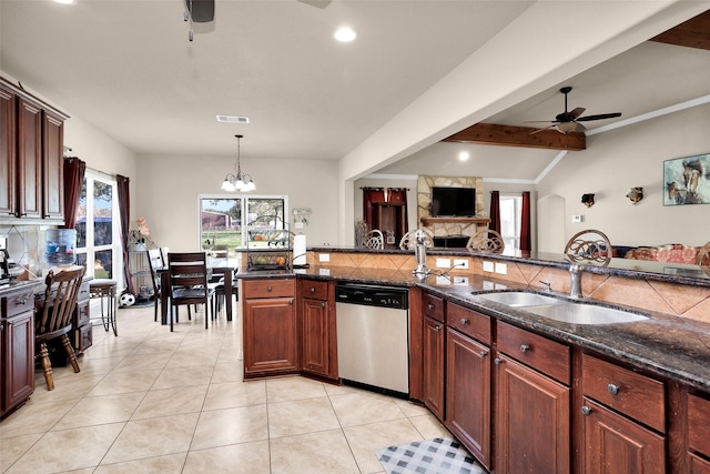 kitchen featuring hanging light fixtures, tasteful backsplash, a stone fireplace, stainless steel dishwasher, and ceiling fan with notable chandelier