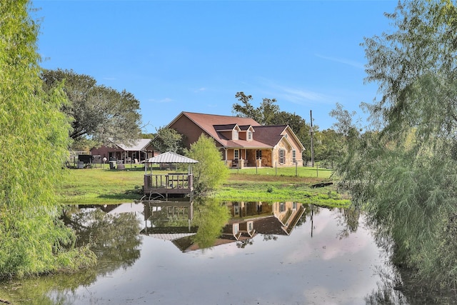 rear view of property featuring a gazebo and a water view