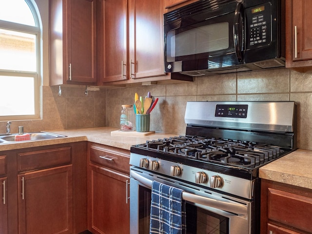 kitchen with backsplash, sink, and stainless steel range with gas stovetop