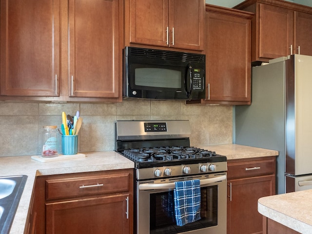 kitchen with decorative backsplash, appliances with stainless steel finishes, and sink