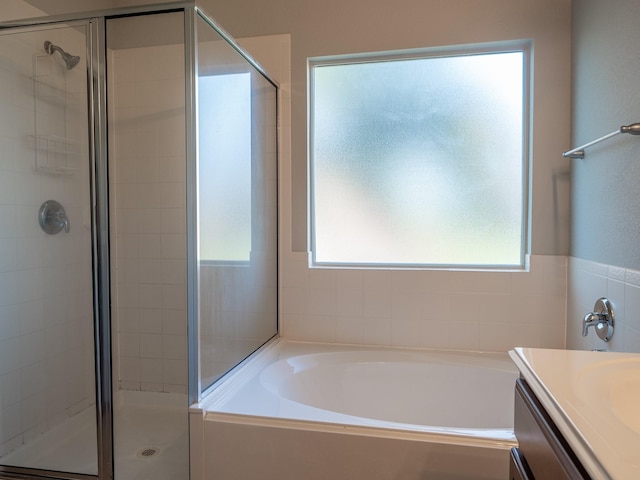 bathroom featuring vanity and independent shower and bath