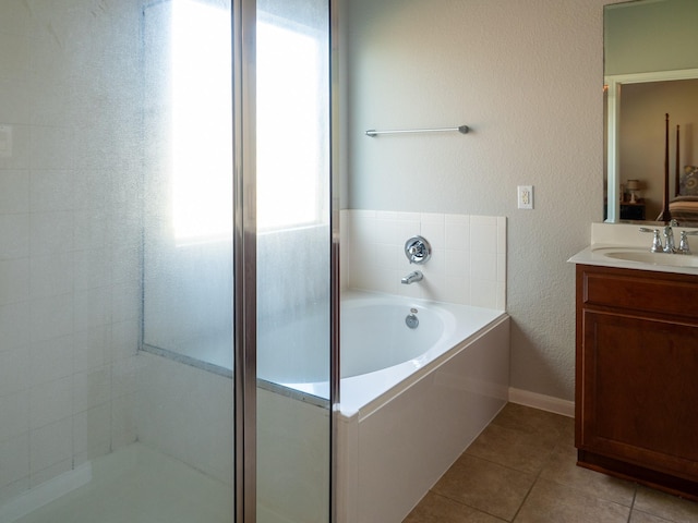 bathroom featuring tile patterned flooring, vanity, a tub, and a healthy amount of sunlight