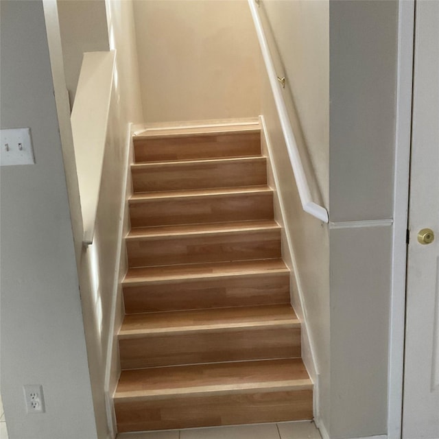 staircase featuring tile patterned flooring