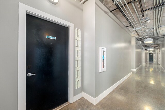 entryway featuring concrete flooring and a high ceiling