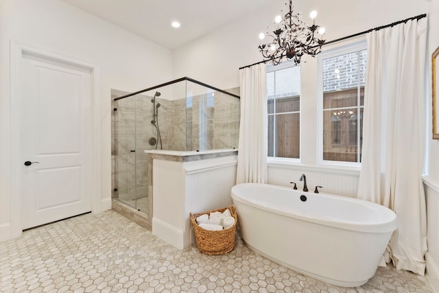 bathroom featuring tile patterned flooring, independent shower and bath, and a notable chandelier