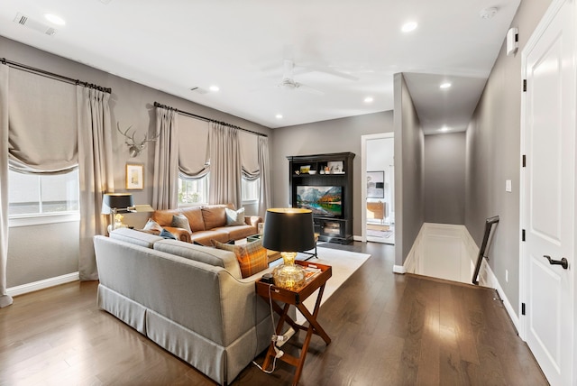 living room featuring a fireplace, ceiling fan, and dark hardwood / wood-style flooring