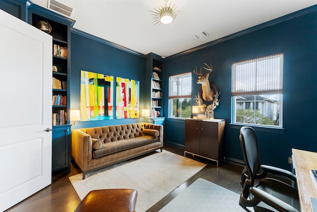 office area featuring built in shelves, ornamental molding, and dark wood-type flooring