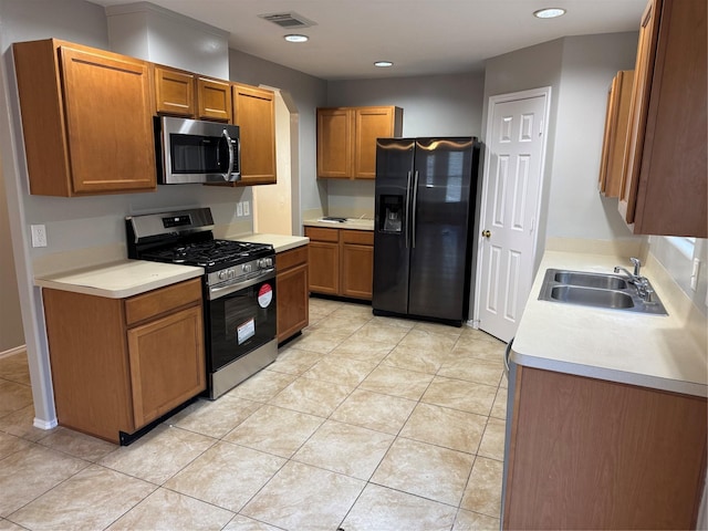 kitchen featuring appliances with stainless steel finishes, light tile patterned floors, and sink