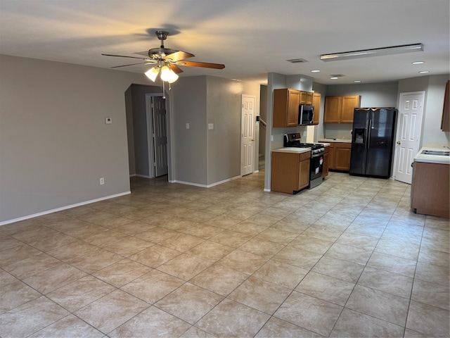 kitchen featuring appliances with stainless steel finishes, light tile patterned floors, ceiling fan, and sink