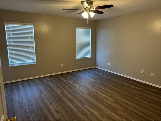 empty room with ceiling fan and dark hardwood / wood-style floors