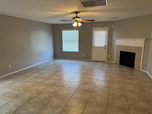 unfurnished living room featuring light tile patterned floors, ceiling fan, and a tiled fireplace