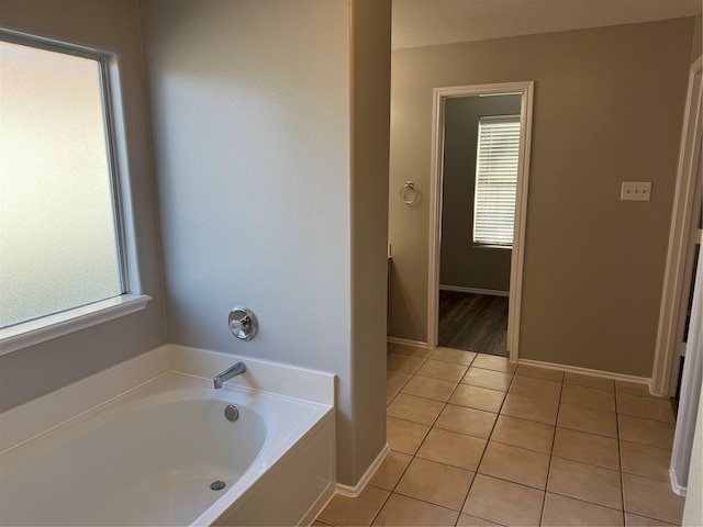 bathroom featuring a tub, tile patterned flooring, and a healthy amount of sunlight