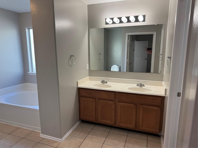 bathroom featuring tile patterned flooring, a washtub, and vanity