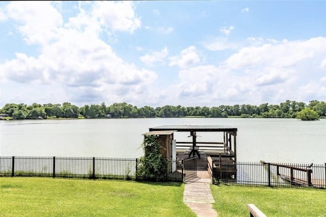 dock area with a lawn and a water view