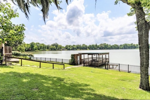 dock area featuring a water view and a lawn