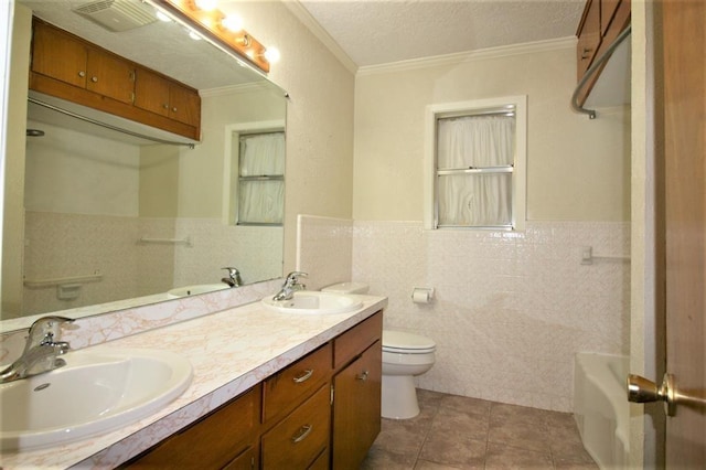 bathroom featuring tile patterned floors, toilet, vanity, tile walls, and ornamental molding