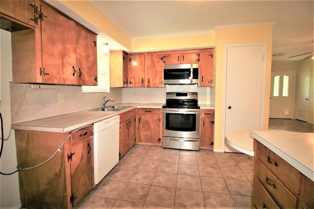 kitchen featuring backsplash, ornamental molding, stainless steel appliances, sink, and light tile patterned floors